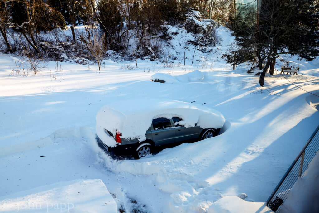 Volvo buried in driveway awaits rescue