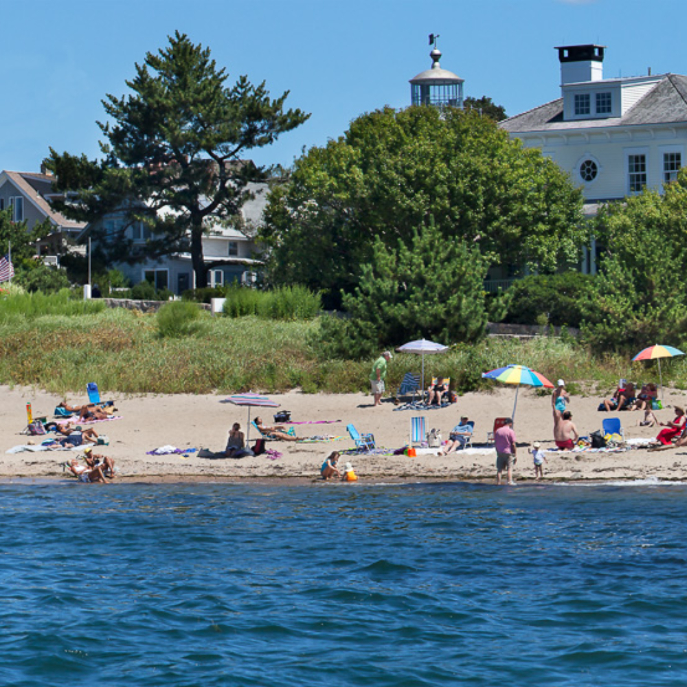 Raft and swimmers and sunbathers enjoy summer at Dubois Beach